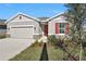 Charming single-story home featuring a front-entry garage, neat landscaping, and red front door and window shutters at 1737 Carnelian St, Deland, FL 32720