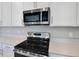 Modern kitchen showcasing stainless steel oven, microwave, and white countertops with tile backsplash at 1737 Carnelian St, Deland, FL 32720