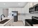 Modern kitchen featuring stainless steel appliances, quartz countertops, and white cabinets at 1737 Carnelian St, Deland, FL 32720