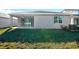 Exterior home view with a grassy back yard, patio, and sunny sky at 1741 Carnelian St, Deland, FL 32720