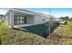 Back yard with a lush lawn, patio, and new construction in the background at 1741 Carnelian St, Deland, FL 32720