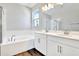 Well-lit bathroom with double vanity, a soaking tub, and wood-style floors at 1741 Carnelian St, Deland, FL 32720