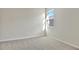 Empty bedroom with soft gray walls, gray carpet, a window, and electrical outlets; ready for personalization at 1741 Carnelian St, Deland, FL 32720