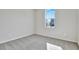 Bright, carpeted bedroom with a large window providing natural light; neutral walls create a serene atmosphere at 1741 Carnelian St, Deland, FL 32720