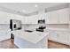 Spacious kitchen featuring white cabinets, stainless steel appliances, a central island, and wood-look tile flooring at 1741 Carnelian St, Deland, FL 32720