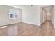 Bright and airy living room with wood-look tile flooring, a large window, and a view into the hallway at 1741 Carnelian St, Deland, FL 32720
