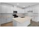 Modern kitchen featuring white cabinetry, stainless steel appliances, quartz countertops and a large center island at 1747 Carnelian St, Deland, FL 32720