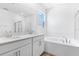 Bathroom with double vanity, soaking tub, and separate glass-enclosed shower at 1749 Carnelian St, Deland, FL 32720