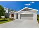 Charming single-Gathering home featuring a well-manicured lawn, gray exterior paint, and an attached two-car garage at 1749 Carnelian St, Deland, FL 32720