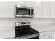 Bright kitchen featuring stainless steel appliances including a microwave and a range, and white countertops at 1749 Carnelian St, Deland, FL 32720