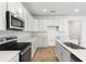 Bright kitchen with white cabinets, quartz countertops, stainless steel appliances, and a center island with a sink at 1749 Carnelian St, Deland, FL 32720