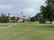 A wide shot of the golf course on a partly cloudy day, with a home in the background, and two storks in the grass at 1750 Saint Tropez Ct, Kissimmee, FL 34744