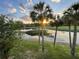 Scenic pond view at sunset framed by palm trees, enhancing the natural beauty of the property at 1750 Saint Tropez Ct, Kissimmee, FL 34744