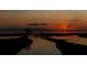 Scenic water view featuring golden sunset over calm water, with silhouette of small land mass in the distance at 1750 Saint Tropez Ct, Kissimmee, FL 34744