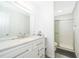 Bright bathroom featuring a quartz countertop vanity, a large mirror, and a glass-enclosed shower at 2031 Ludlow Ln # 3303, Orlando, FL 32839