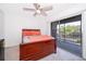 Bedroom with ceiling fan and sliding doors to a balcony that let in natural light at 2031 Ludlow Ln # 3303, Orlando, FL 32839