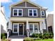 Charming two-story home featuring a welcoming front porch with stylish columns and beautifully landscaped yard at 2057 Celebration Blvd, Celebration, FL 34747