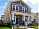 Attractive two-story home displaying a cozy front porch with columns and meticulously maintained landscaping at 2057 Celebration Blvd, Celebration, FL 34747