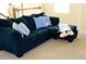 Comfortable blue sectional sofa featuring patterned throw pillows and blanket in a brightly lit living area at 2057 Celebration Blvd, Celebration, FL 34747