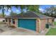 Back exterior of the house featuring an attached blue garage and a well-maintained backyard at 2081 N Normandy Blvd, Deltona, FL 32725