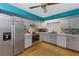 Well-lit kitchen features gray cabinets, stainless steel appliances, mosaic backsplash and hardwood flooring at 2081 N Normandy Blvd, Deltona, FL 32725
