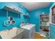 Bright laundry room with blue walls, open shelving, utility sink, and included washer and dryer at 2081 N Normandy Blvd, Deltona, FL 32725