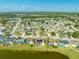 Aerial view showcases a lovely neighborhood near a lake, highlighting homes with pools and solar panel installations at 2322 Queenswood Cir, Kissimmee, FL 34743