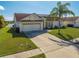 Inviting single-story home with a two-car garage, solar panels, and a well-kept lawn in a serene neighborhood at 2322 Queenswood Cir, Kissimmee, FL 34743