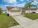 Inviting single-Gathering home featuring a well-manicured lawn and convenient two-car garage at 2322 Queenswood Cir, Kissimmee, FL 34743