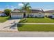 A charming single-story home boasts lush landscaping, a spacious driveway, and a welcoming entrance at 2322 Queenswood Cir, Kissimmee, FL 34743