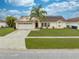Inviting single-Gathering home with a manicured lawn, palm tree, and solar panels, located in a friendly neighborhood at 2322 Queenswood Cir, Kissimmee, FL 34743