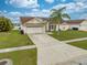 Charming single-Gathering home with a two-car garage, well-kept lawn, and beautiful landscaping in a residential neighborhood at 2322 Queenswood Cir, Kissimmee, FL 34743