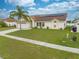 Charming single-Gathering home with a well-kept lawn, solar panels, and tropical landscaping in a residential area at 2322 Queenswood Cir, Kissimmee, FL 34743