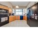 Functional kitchen with wood cabinets, black appliances, and a window overlooking the water at 2322 Queenswood Cir, Kissimmee, FL 34743
