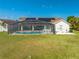 Beautiful home showcasing a screened-in pool area, lush green lawn, and solar panels for sustainable energy at 2322 Queenswood Cir, Kissimmee, FL 34743