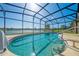 This screened in pool overlooks a calming lake with a lush outdoor landscape view at 2322 Queenswood Cir, Kissimmee, FL 34743