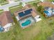 Aerial view of a home featuring a screened-in pool, solar panels, and a well-maintained backyard at 2322 Queenswood Cir, Kissimmee, FL 34743