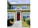 Inviting townhouse with a vibrant red front door and well-manicured landscaping at 2610 Lodi Cir # 104, Kissimmee, FL 34746
