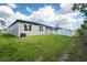 View of the backyard with a well-maintained lawn, privacy fence, and partial view of neighboring homes at 2872 Lingo Ln, Orlando, FL 32822