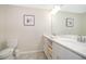 Bright bathroom featuring dual sinks, white cabinetry, and coastal-themed decor at 3120 Paradox Cir # 302, Kissimmee, FL 34746