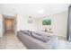 Cozy living room featuring a plush gray sectional sofa, TV, and access to the hallway at 3120 Paradox Cir # 302, Kissimmee, FL 34746
