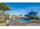 A swimming pool with a water slide surrounded by palm trees and lounge chairs at 3120 Paradox Cir # 302, Kissimmee, FL 34746