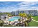 A resort-style pool is surrounded by palm trees, lounge chairs, and modern apartment buildings at 3120 Paradox Cir # 302, Kissimmee, FL 34746
