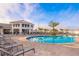 Community pool with lounge chairs, umbrellas, and beautiful palm trees at 3120 Paradox Cir # 302, Kissimmee, FL 34746