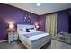 Bedroom with a purple accent wall, modern decor, nightstands, and carpet at 4213 Paragprah St, Kissimmee, FL 34746