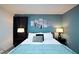 Well-lit bedroom with soft teal walls, sleek black furniture, and minimalist Star Wars decor at 4213 Paragprah St, Kissimmee, FL 34746