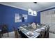 Bright dining room features a modern lighting fixture, seating for ten and blue accent wall at 4213 Paragprah St, Kissimmee, FL 34746