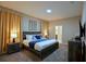 Carpeted main bedroom with a king bed, a television, and warm recessed and lamp lighting at 4213 Paragprah St, Kissimmee, FL 34746