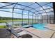 Beautiful screened-in pool area with lounge chairs and lake view at 4213 Paragprah St, Kissimmee, FL 34746