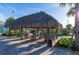 Thatched tiki hut with seating, next to a sparkling community pool and lush landscaping at 4213 Paragprah St, Kissimmee, FL 34746